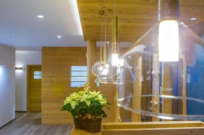 a dining room with wooden walls and a chandelier at Hotel Garni Broi - Charme & Relax in Selva di Val Gardena