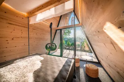 a living room with wooden walls and a large window at Camping Seiser Alm in Fiè