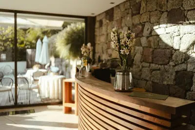 a restaurant with a counter with flowers on it at Hotel Villa Freiheim in Merano