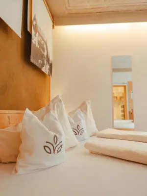 two white pillows on a bed with a mirror at Hotel Villa Freiheim in Merano