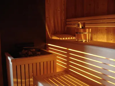 a wooden sauna with sunlight shining on the wall at Miraval NaturHotel in Badia