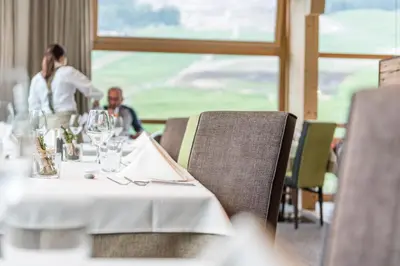 a table in a restaurant with a man and a woman at Miraval NaturHotel in Badia
