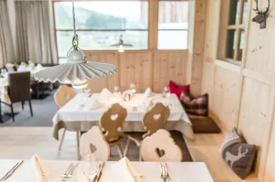 a dining room with a white table and chairs at Miraval NaturHotel in Badia
