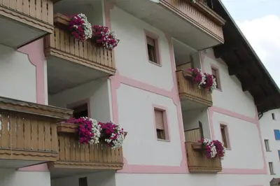 a building with flower boxes on the balconies at Hotel Garnì Miramonti in Falcade