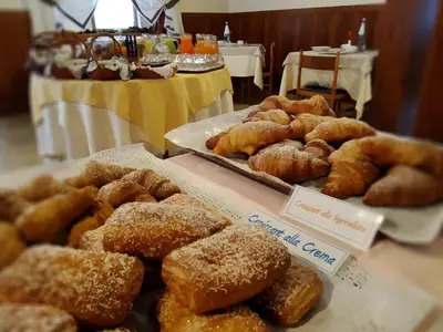 a display of donuts and pastries on a table at Hotel Garnì Miramonti in Falcade