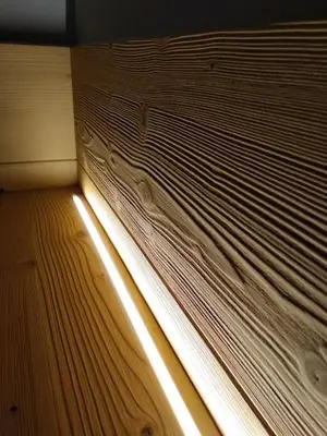a wooden wall with a window with the light shining through at Hotel Garnì Miramonti in Falcade