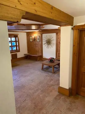 a living room with a table and a wooden ceiling at Casa Peragallo Cortina in Cortina dʼAmpezzo