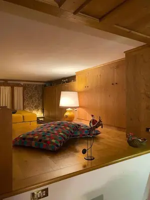 a bedroom with a bed and a lamp on the floor at Casa Peragallo Cortina in Cortina dʼAmpezzo