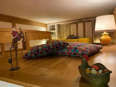 a bed in a room with a bowl of fruit on the floor at Casa Peragallo Cortina in Cortina dʼAmpezzo