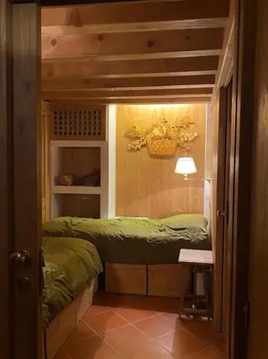 a small room with two beds and a table at Casa Peragallo Cortina in Cortina dʼAmpezzo
