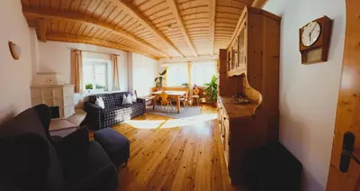 a living room with a clock on a wooden ceiling at Villa Andre in Tires