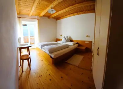 a bedroom with a bed and a table and a window at Villa Andre in Tires