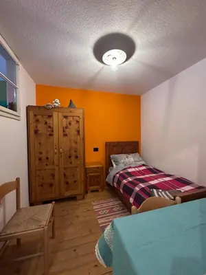 a bedroom with a bed and a dresser at Oma Nani in Campitello di Fassa