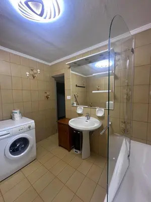 a bathroom with a washing machine and a sink at Oma Nani in Campitello di Fassa