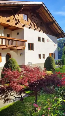 a large building with a wooden roof and some flowers at Mitterhofer in Villandro