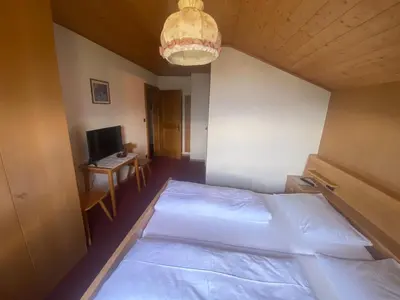 a bedroom with a bed and a desk with a computer at Mitterhofer in Villandro