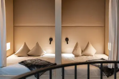 a bed with pillows on it in a room at Schwarzer Adler - Concept Living in Vipiteno