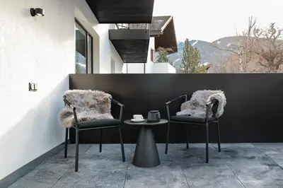 two chairs and a table with a cup of coffee at Schwarzer Adler - Concept Living in Vipiteno