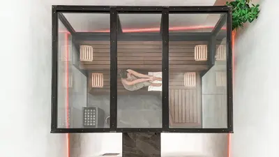 a woman is sitting in a room behind a window at Schwarzer Adler - Concept Living in Vipiteno