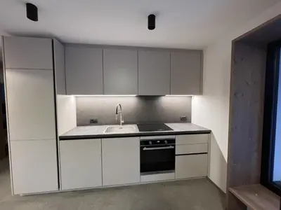 a kitchen with white cabinets and a sink at Sottla - your mountain home in Valdaora