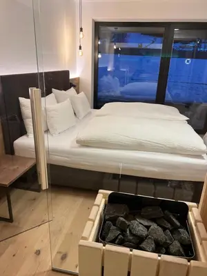 a bedroom with a bed with a glass wall at Sottla - your mountain home in Valdaora