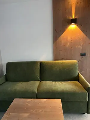 a green couch with a coffee table in a room at Sottla - your mountain home in Valdaora