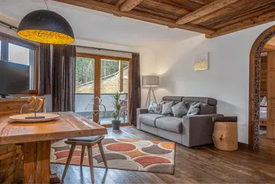 a living room with a couch and a table at Alpine Mountain Chalet in San Vigilio Di Marebbe