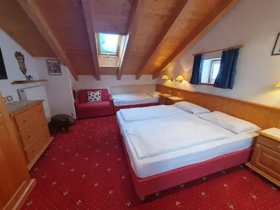 a large bedroom with two beds and a couch at Apartments Somavia in Ortisei