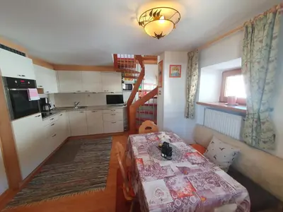 a small kitchen with a table and a dining room at Apartments Somavia in Ortisei