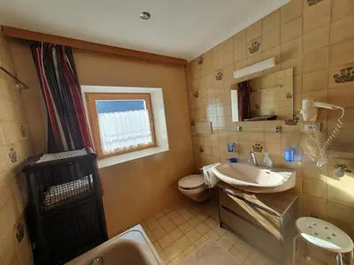 a bathroom with a sink and a toilet and a window at Apartments Somavia in Ortisei