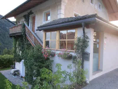a house with a balcony and flowers on it at Apartments Somavia in Ortisei