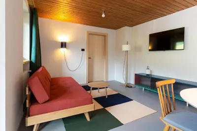a living room with a red couch and a table at MiraOdle Apartments in Villnoss