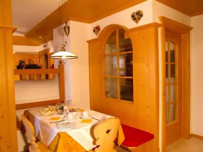 a dining room with a table in a kitchen at Design Chalet Zirm - check-in at Olympia Hotel in Varda
