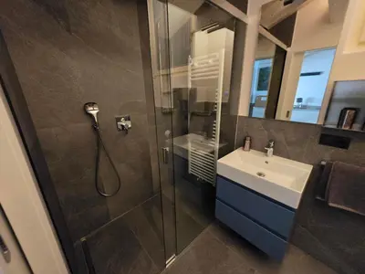 a bathroom with a glass shower and a sink at Sweet Piccolino in Merano