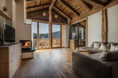 a living room with a couch and a fireplace at Appartements Chalet Bandiarac in San Cassiano