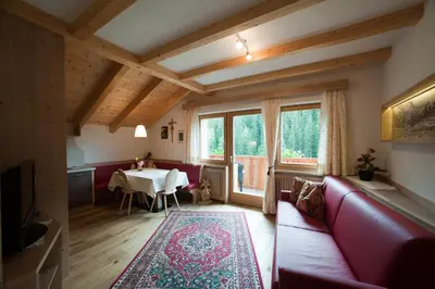 a living room with a red couch and a table at Lüch da Mirió in La Valle