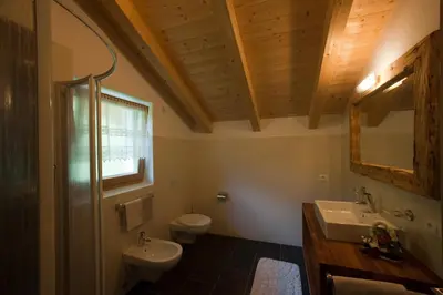 a bathroom with a sink and a toilet and a mirror at Lüch da Mirió in La Valle