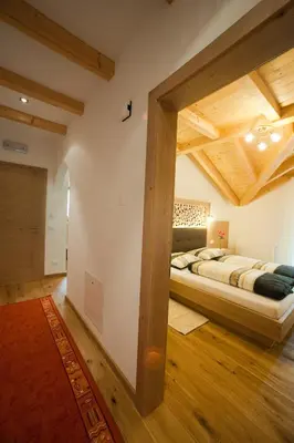 a bedroom with a large bed in a room with wooden ceilings at Lüch da Mirió in La Valle