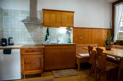 a kitchen with wooden cabinets and a sink and a table at Masito Apartments The Hub in Cortina dʼAmpezzo