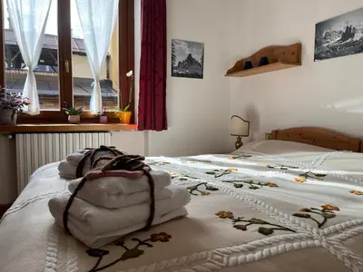 a bedroom with a bed with towels on it at Masito Apartments The Hub in Cortina dʼAmpezzo