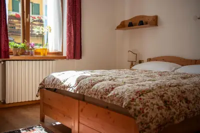 a bedroom with a bed and a window at Masito Apartments The Hub in Cortina dʼAmpezzo