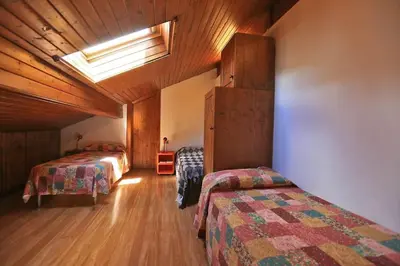 a bedroom with two beds and a skylight at Nel cuore delle Dolomiti fino a 8 persone in Vigo di Fassa