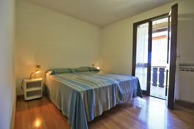 a bedroom with a bed and a large window at Nel cuore delle Dolomiti fino a 8 persone in Vigo di Fassa