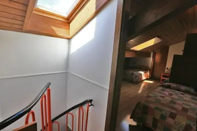 an attic room with a bed and a window at Nel cuore delle Dolomiti fino a 8 persone in Vigo di Fassa