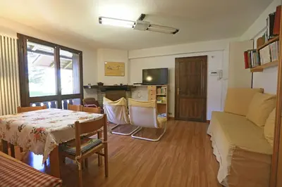 a living room with a table and a couch at Nel cuore delle Dolomiti fino a 8 persone in Vigo di Fassa