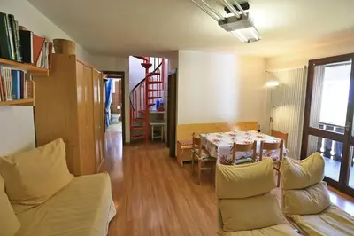 a living room with a dining room table and chairs at Nel cuore delle Dolomiti fino a 8 persone in Vigo di Fassa