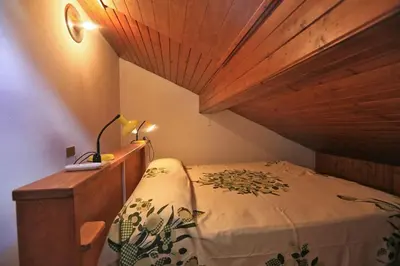 a bedroom with a bed and a wooden ceiling at Nel cuore delle Dolomiti fino a 8 persone in Vigo di Fassa