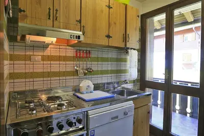 a kitchen with a stove and a sink at Nel cuore delle Dolomiti fino a 8 persone in Vigo di Fassa