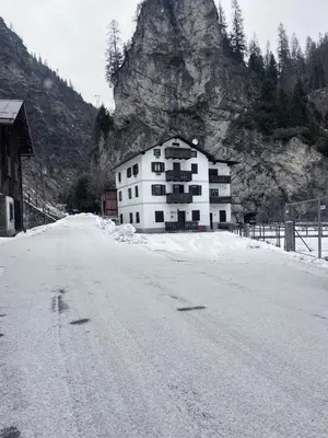 a building on the side of a snow covered road at Casa di Charme sul Civetta Dolomiti in Caprile