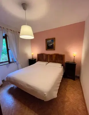 a bedroom with a large white bed and a lamp at Casa di Charme sul Civetta Dolomiti in Caprile